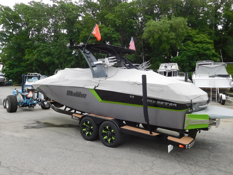 Slide: The Image of 2017 Malibu Wakesetter 24 MXZ boat on trailer with cover in marina. - 12