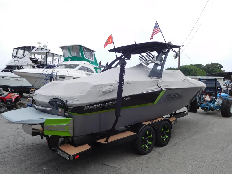 Slide: The Image of 2017 Malibu Wakesetter 24 MXZ boat covered and on a trailer at a marina. - 13