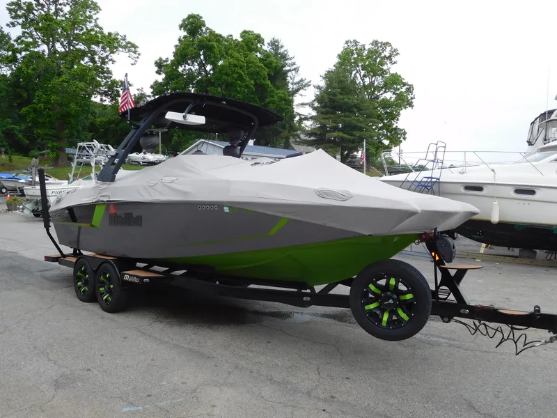 Slide: The Image of 2017 Malibu Wakesetter 24 MXZ boat on trailer with cover, parked at marina. - 14