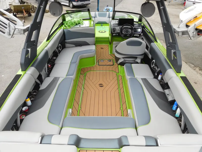 Slide: The Image of 2017 Malibu Wakesetter 24 MXZ interior with green and gray seating, wood flooring. - 17