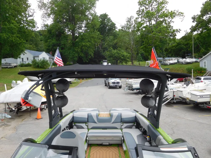 Slide: The Image of 2017 Malibu Wakesetter 24 MXZ boat with tower speakers and flags, parked in a marina. - 45
