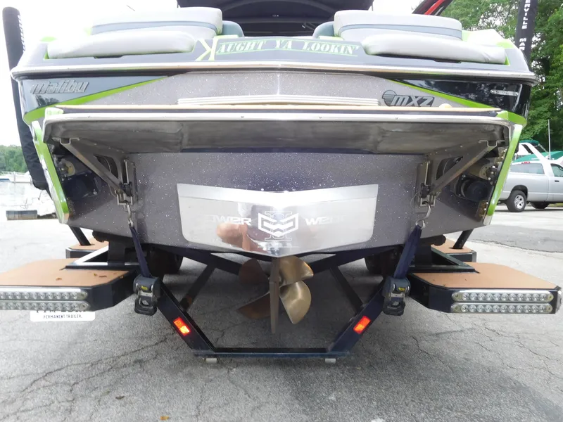 Slide: The Image of 2017 Malibu Wakesetter 24 MXZ boat rear view with propeller and trailer. - 7