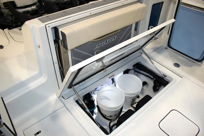 Slide: The Image of 2024 Blackfin 302 DC boat storage compartment with buckets and equipment. - 5