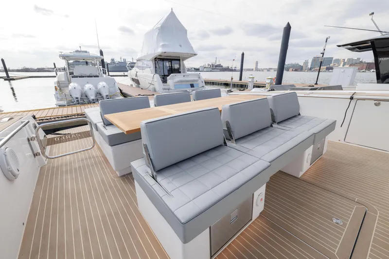 Slide: The Image of 2024 Pardo Yachts 43, luxury yacht deck with seating and table, docked at marina. - 15