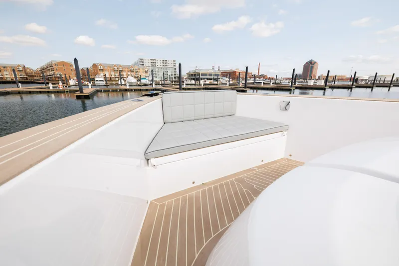 Slide: The Image of 2024 Pardo Yachts 43 with cushioned seating area at the bow, docked in a marina. - 33