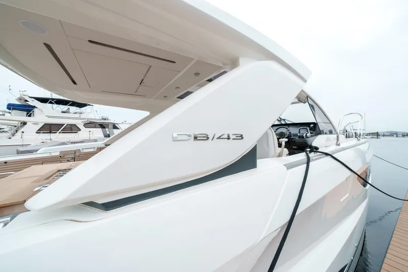 Slide: The Image of 2024 Jeanneau DB|43 Outboard yacht docked, showcasing sleek design and modern features. - 13
