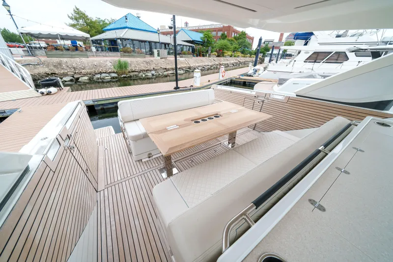 Slide: The Image of 2024 Jeanneau DB|43 Outboard yacht with elegant seating and wooden deck at a marina. - 27
