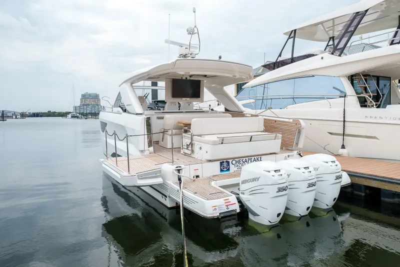 Slide: The Image of 2024 Jeanneau DB|43 Outboard boat docked with triple engines, rear view. - 48