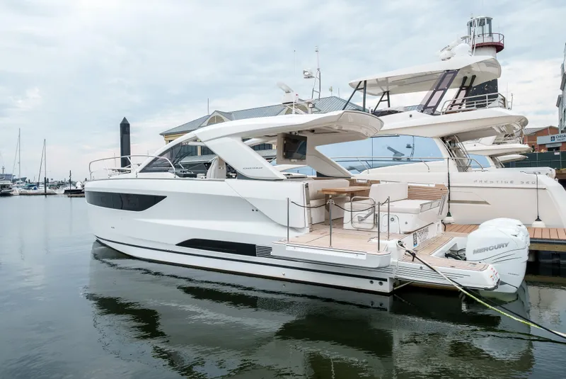 Slide: The Image of 2024 Jeanneau DB|43 Outboard yacht docked in a marina, showcasing sleek design and luxury features. - 49