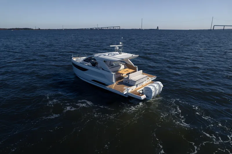 Slide: The Image of 2024 Jeanneau DB|43 Outboard cruising on open water, showcasing sleek design and powerful engines. - 9