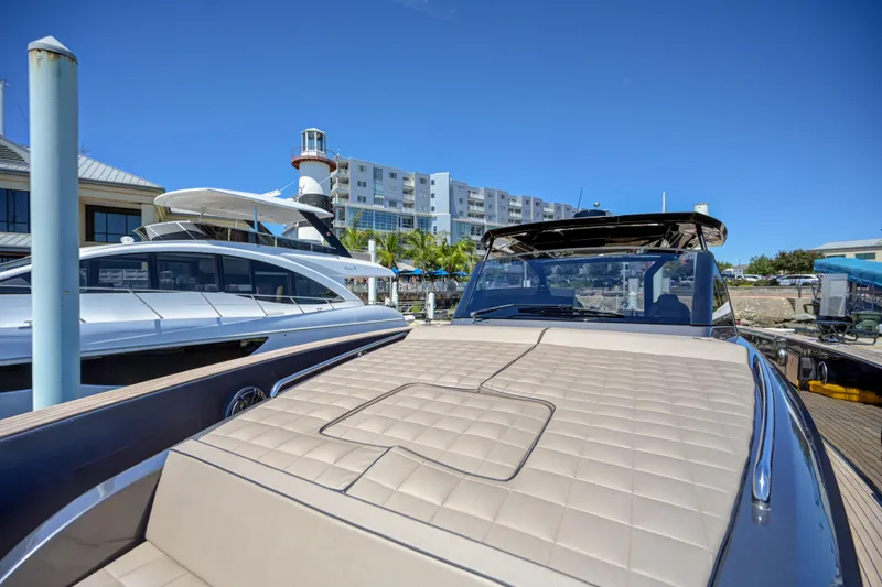 Slide: The Image of 2025 Pardo Yachts 50 docked at a marina with a lighthouse and buildings in the background. - 31
