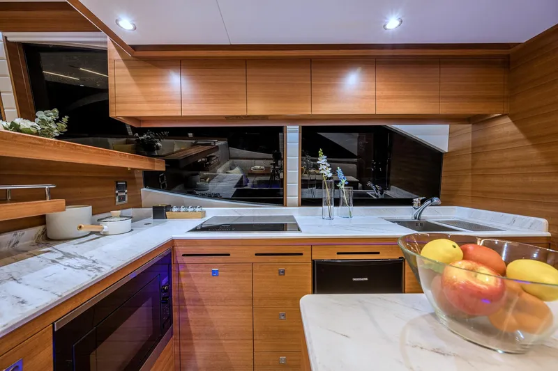 Slide: The Image of Modern kitchen interior on 2025 Dyna 63 yacht with wooden cabinets and marble countertops. - 20