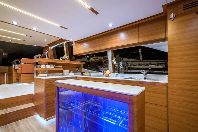 Slide: The Image of Luxurious interior of 2025 Dyna 63 yacht with modern kitchen and blue-lit wine storage. - 23