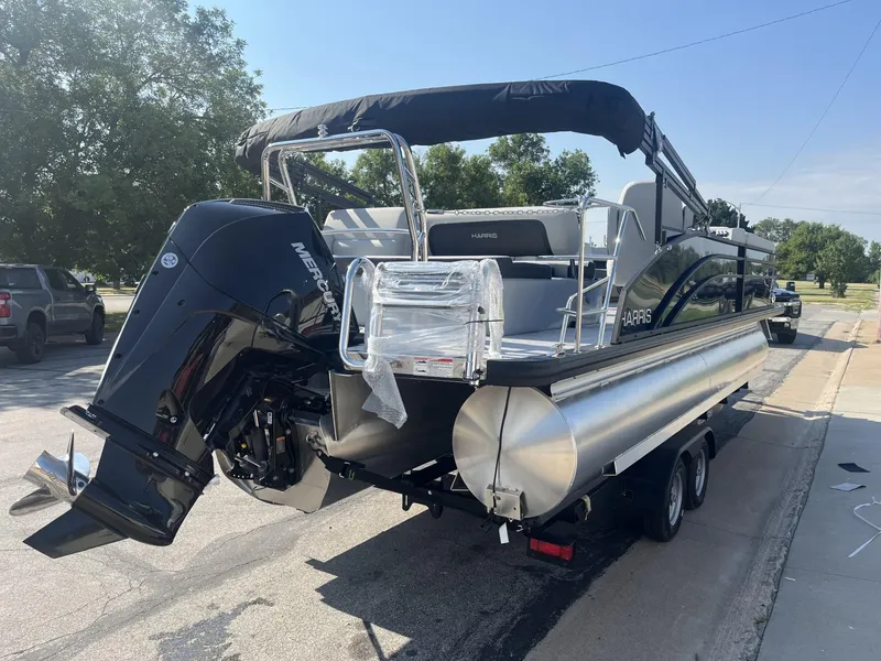 Slide: The Image of 2025 Harris Cruiser 250 pontoon boat on trailer, featuring a powerful outboard motor. - 4