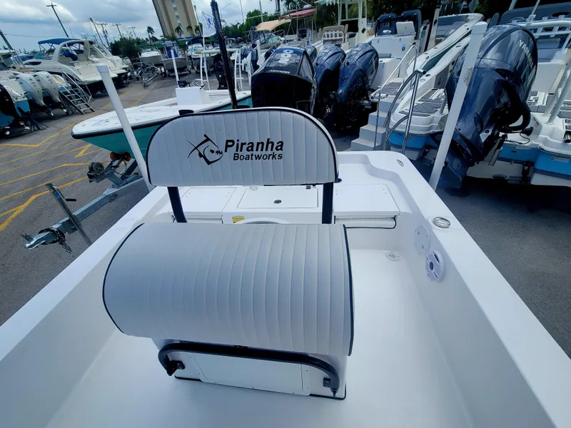 Slide: The Image of 2025 Piranha Casador B2200 boat interior with seating, docked among other boats. - 13