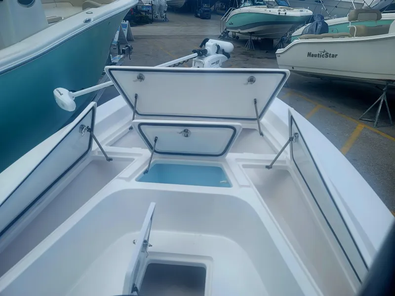 Slide: The Image of 2025 Piranha Casador B2200 boat with open storage compartments in a marina setting. - 18