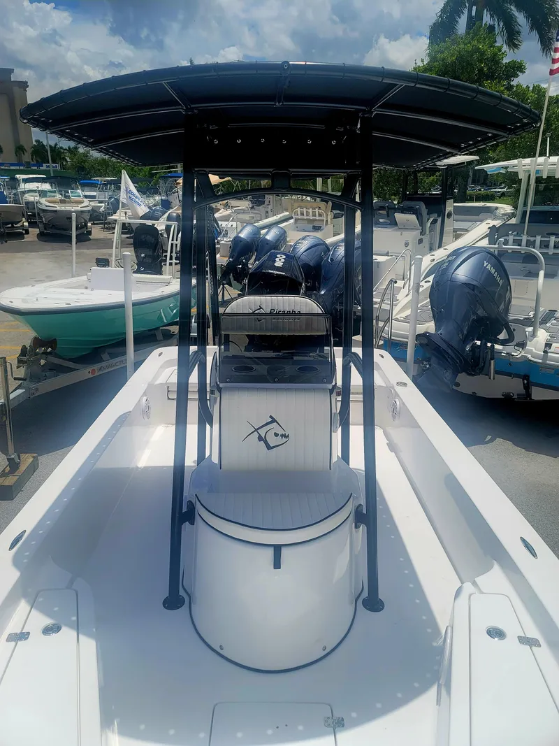 Slide: The Image of 2025 Piranha Casador B2200 boat with T-top, docked among other boats. - 7