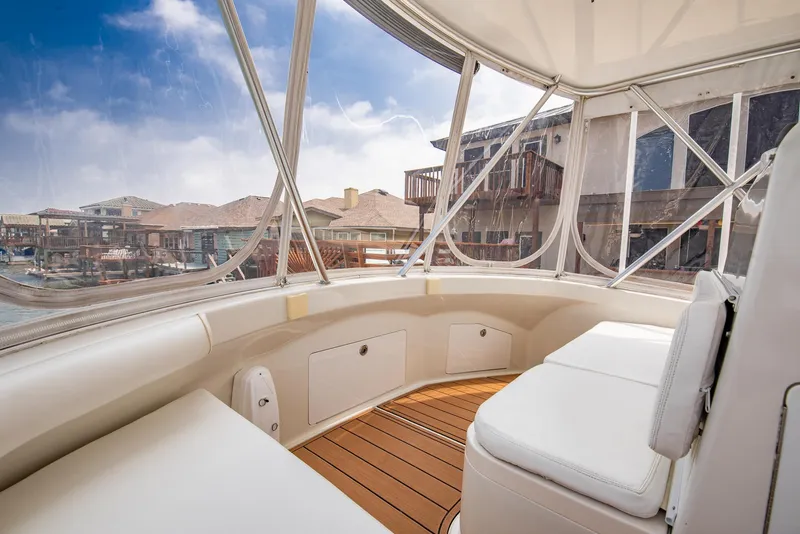 Slide: The Image of 2002 Cabo Convertible Painted boat interior with white seating and wooden flooring. - 12