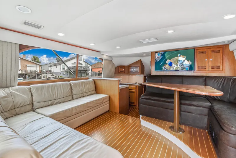 Slide: The Image of Interior of a 2002 Cabo Convertible Painted yacht with leather seating and wooden flooring. - 14