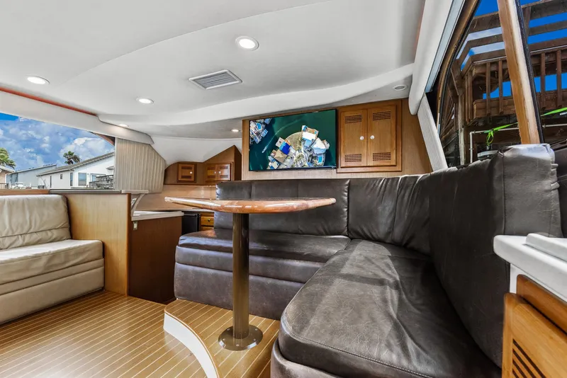 Slide: The Image of Interior of a 2002 Cabo Convertible Painted yacht with leather seating and wooden accents. - 17