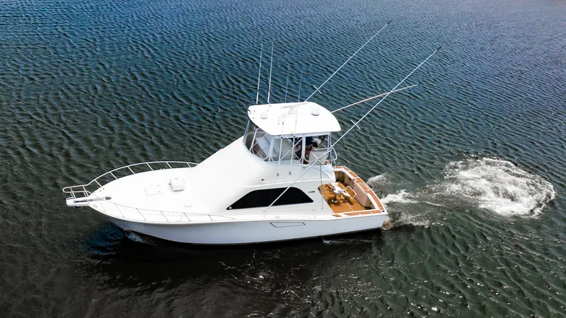 Slide: The Image of 2002 Cabo Convertible Painted boat cruising on open water. - 2