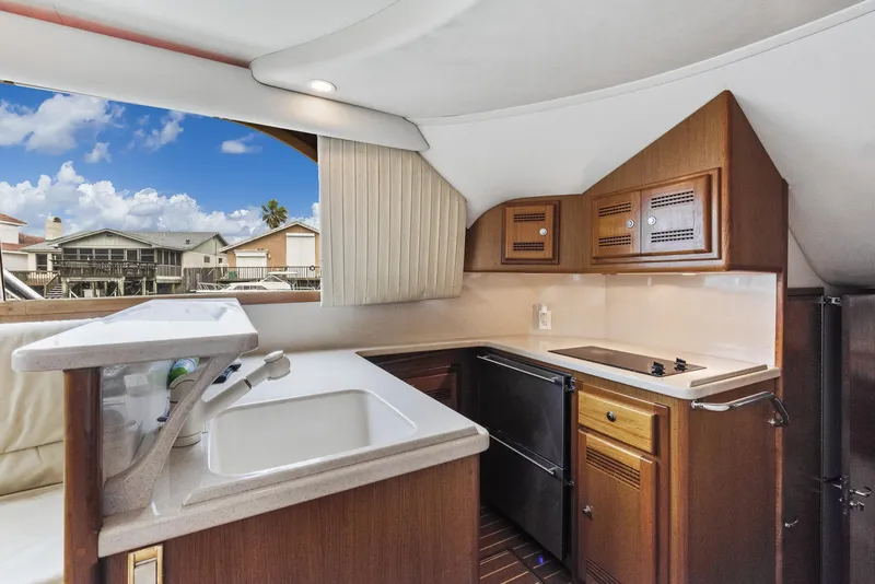 Slide: The Image of 2002 Cabo Convertible Painted yacht kitchen with sink, stove, and cabinets. - 20