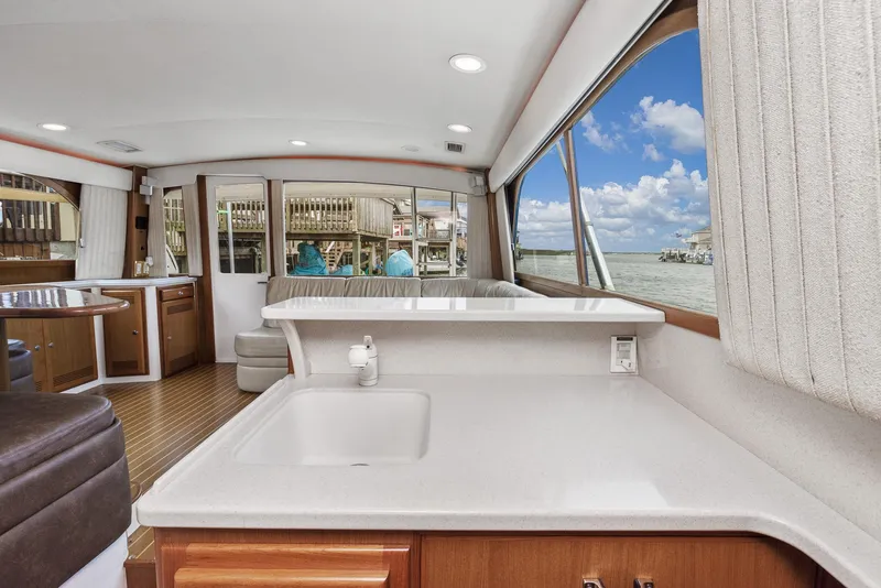 Slide: The Image of Interior of 2002 Cabo Convertible Painted boat with ocean view through large windows. - 21