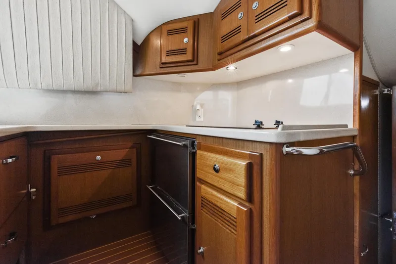 Slide: The Image of 2002 Cabo Convertible Painted boat kitchen with wooden cabinets and modern appliances. - 24