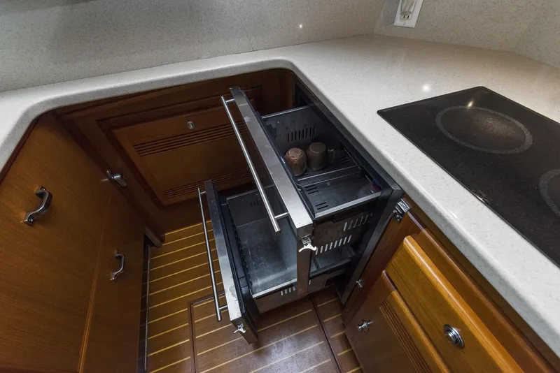 Slide: The Image of 2002 Cabo Convertible Painted yacht kitchen with open drawers and stove. - 26