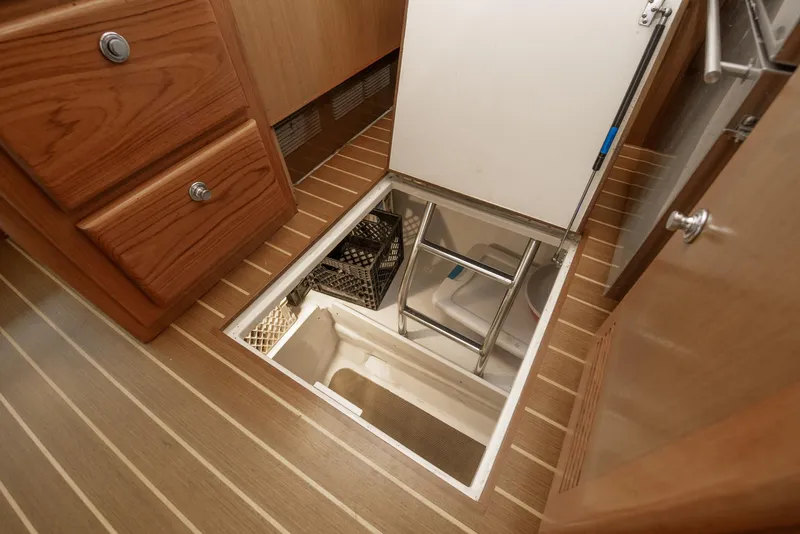 Slide: The Image of 2002 Cabo Convertible Painted boat interior with open floor storage compartment. - 28