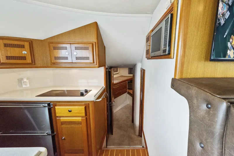 Slide: The Image of 2002 Cabo Convertible Painted boat interior with kitchenette and hallway to sleeping quarters. - 29