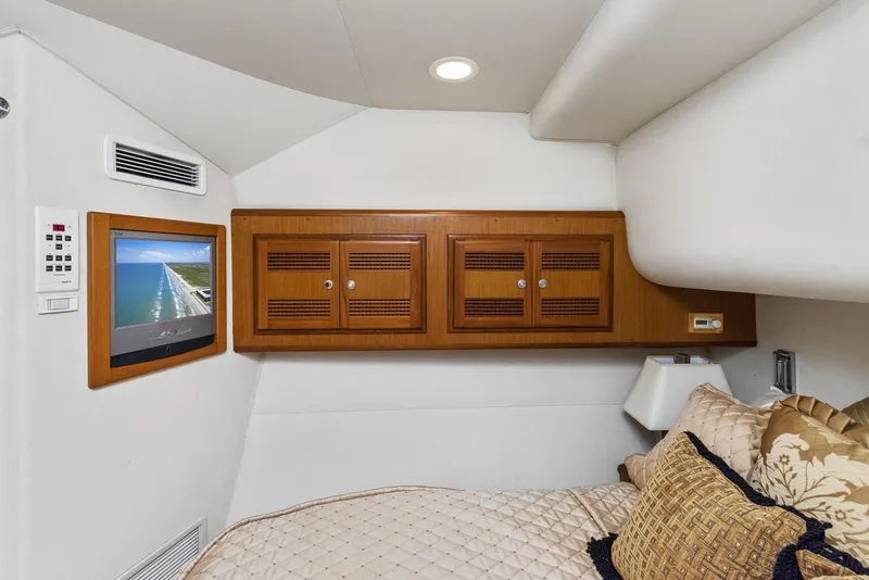 Slide: The Image of 2002 Cabo Convertible Painted yacht interior with TV and wooden cabinets. - 33