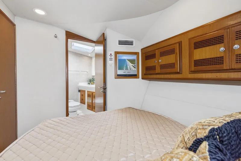 Slide: The Image of 2002 Cabo Convertible Painted boat interior with cozy bedroom and bathroom. - 34