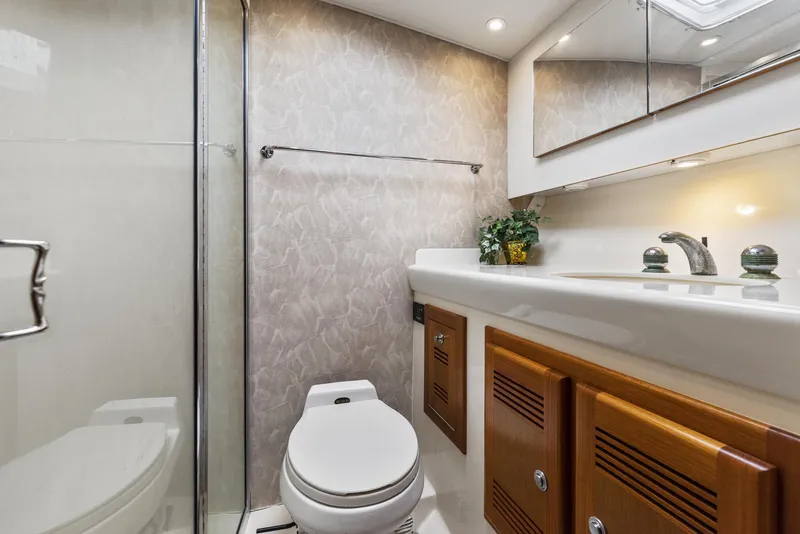 Slide: The Image of 2002 Cabo Convertible Painted yacht bathroom with modern fixtures and wooden cabinetry. - 36
