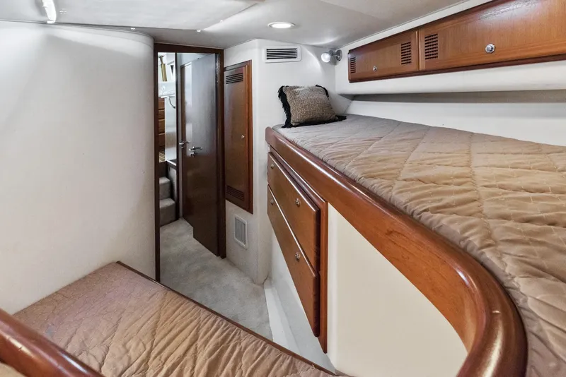 Slide: The Image of 2002 Cabo Convertible Painted yacht interior with bunk beds and wooden cabinetry. - 41