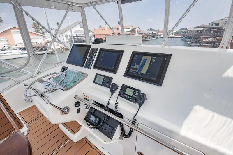 Slide: The Image of 2002 Cabo Convertible Painted boat helm with navigation screens and controls. - 7