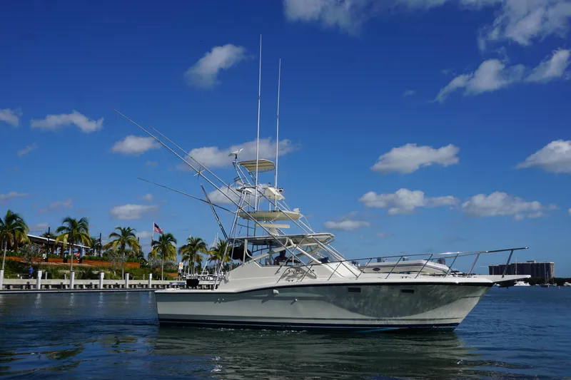 Slide: The Image of 1985 Hatteras 36 Convertible yacht on calm water with a clear blue sky. - 10