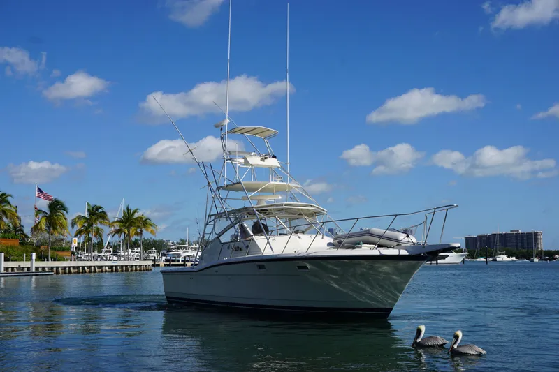 Slide: The Image of 1985 Hatteras 36 Convertible yacht on calm waters with blue sky. - 12