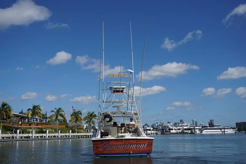 Slide: The Image of 1985 Hatteras 36 Convertible boat named Commitment docked in a marina with palm trees. - 17