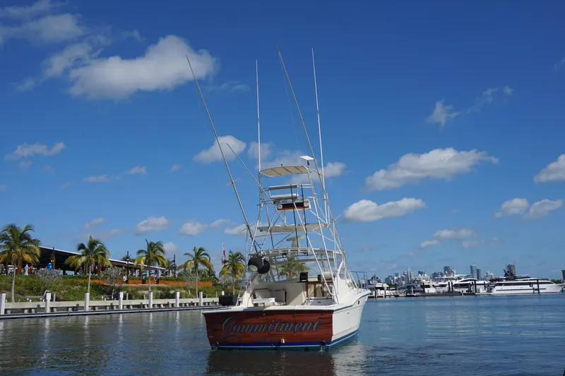 Slide: The Image of 1985 Hatteras 36 Convertible boat docked in a marina with a clear blue sky. - 18