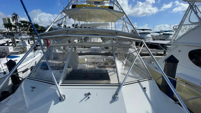 Slide: The Image of 1985 Hatteras 36 Convertible yacht docked at a marina under a clear blue sky. - 21