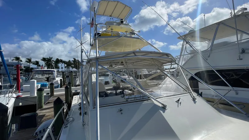 Slide: The Image of 1985 Hatteras 36 Convertible yacht docked at marina under blue sky. - 22