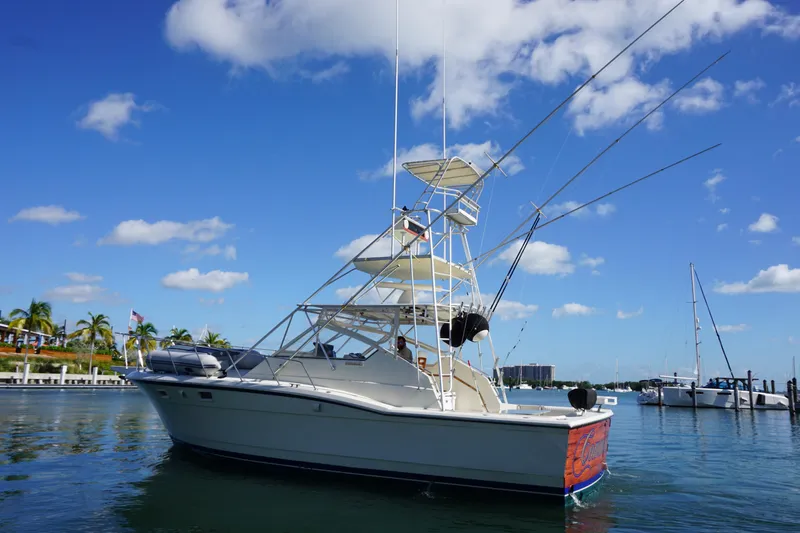 Slide: The Image of 1985 Hatteras 36 Convertible boat on calm water under blue sky. - 3