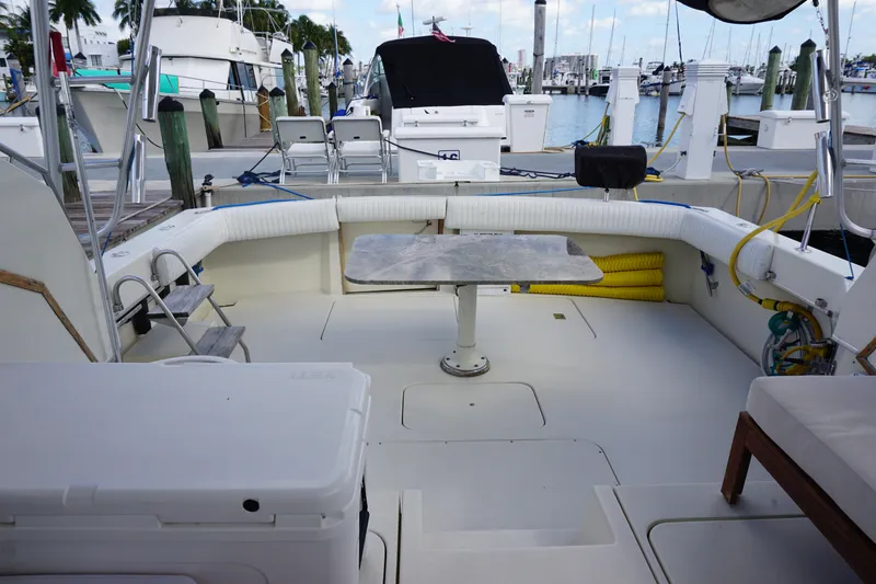 Slide: The Image of 1985 Hatteras 36 Convertible boat deck with seating and table in marina. - 37