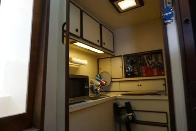 Slide: The Image of 1985 Hatteras 36 Convertible boat kitchen with cabinets and appliances. - 47