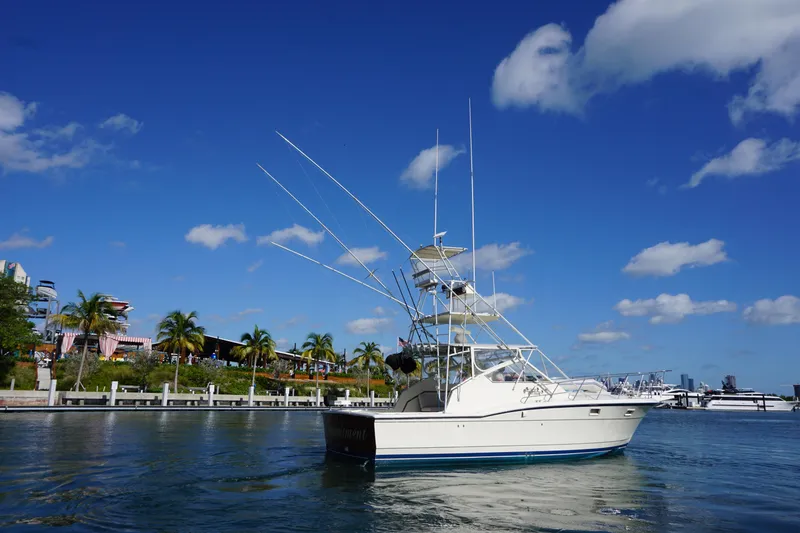 Slide: The Image of 1985 Hatteras 36 Convertible boat docked near a tropical shoreline. - 7