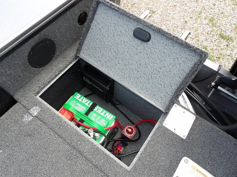 Slide: The Image of Open battery compartment in 2019 Lund 1975 Pro V Sport boat, featuring Interstate battery. - 17