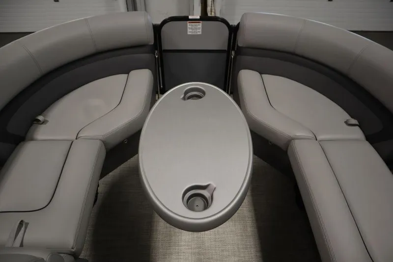 Slide: The Image of 2023 Trifecta 24UL CS 2.75 boat interior with gray seating and oval table. - 23
