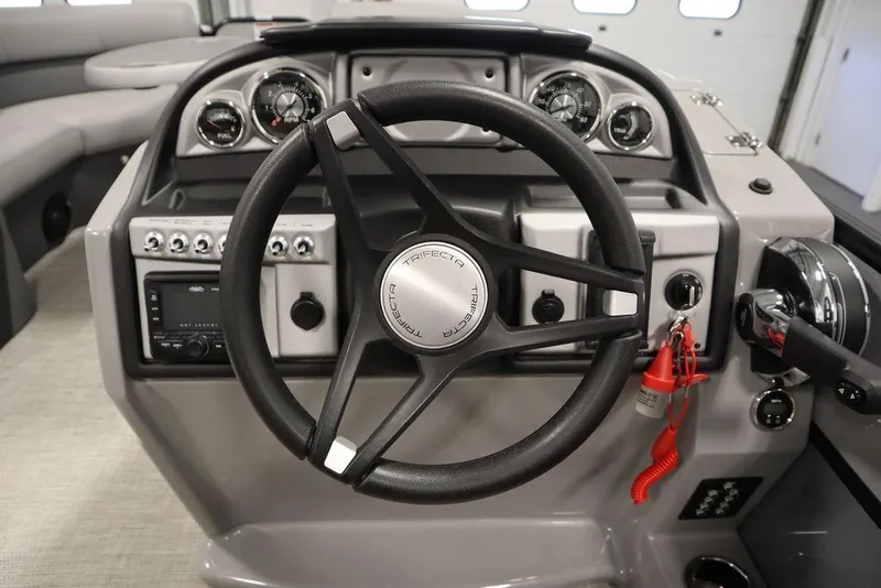 Slide: The Image of 2023 Trifecta 24UL CS 2.75 boat dashboard with steering wheel and control panel. - 28