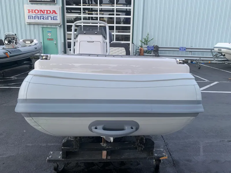 Slide: The Image of 2026 Highfield Sport 330 inflatable boat with Tohatsu engine, displayed indoors. - 8